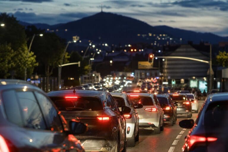 Reihe von Autos im Stau mit leuchtenden Bremslichtern auf einer Straße bei Nacht