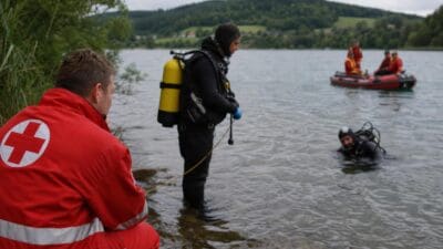 Rettungskräfte und Taucher bei einer Suchaktion am Seeufer mit Schlauchboot