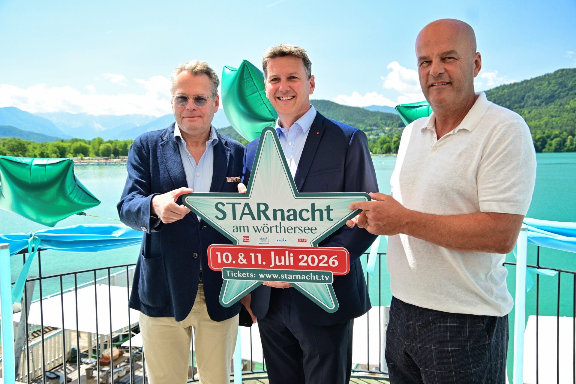 Drei Männer halten ein großes Sternschild für die Starnacht am Wörthersee.