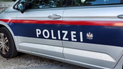 Seitenansicht eines silbernen Polizeiautos mit der Aufschrift POLIZEI und dem österreichischen Wappen