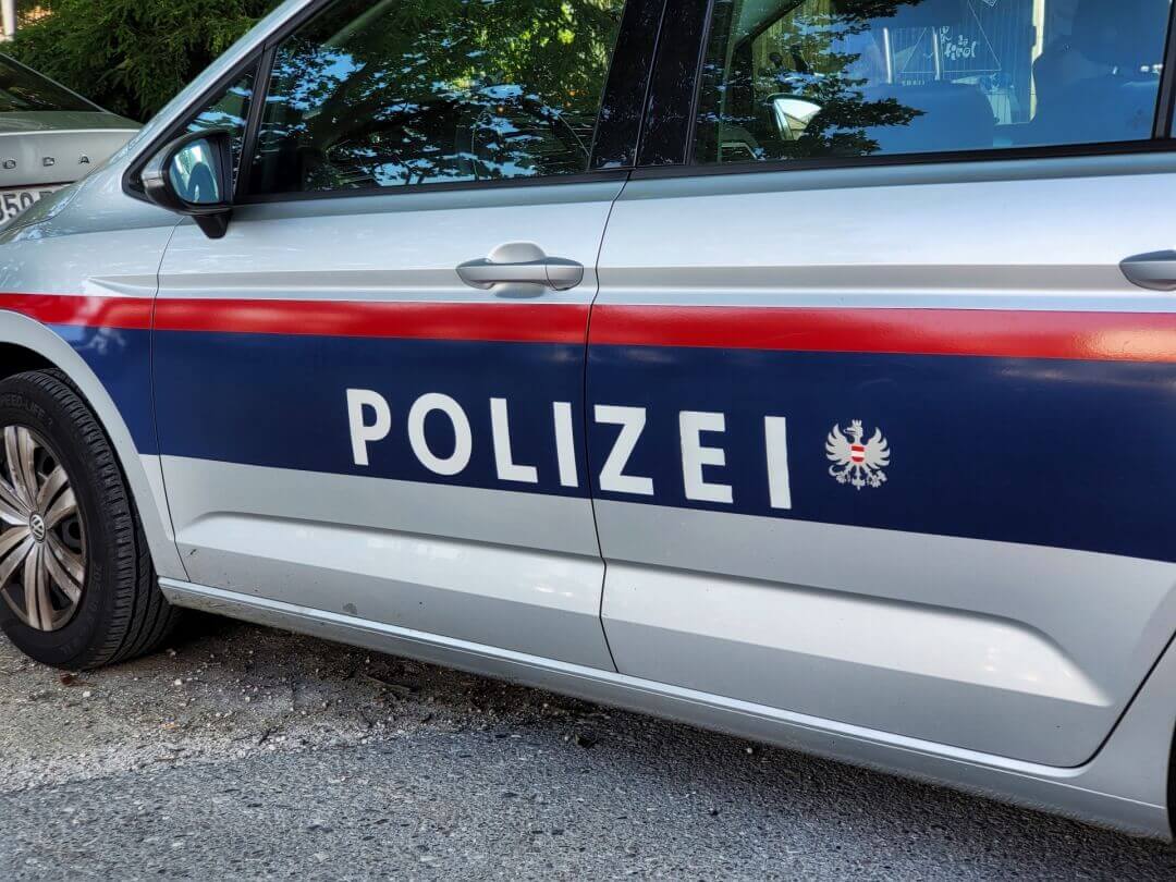 Seitenansicht eines silbernen Polizeiautos mit der Aufschrift POLIZEI und dem österreichischen Wappen