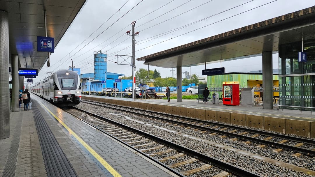 Moderner grauer Doppelstockzug der ÖBB am Bahnsteig des Hauptbahnhofs Salzburg