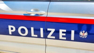 Nahaufnahme der Seitenfläche eines österreichischen Polizeiwagens mit der Aufschrift POLIZEI und dem Bundesadler