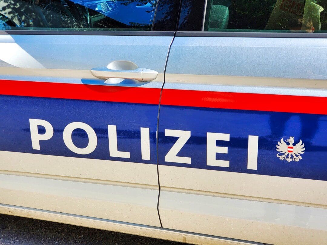 Nahaufnahme der Seitenfläche eines österreichischen Polizeiwagens mit der Aufschrift POLIZEI und dem Bundesadler