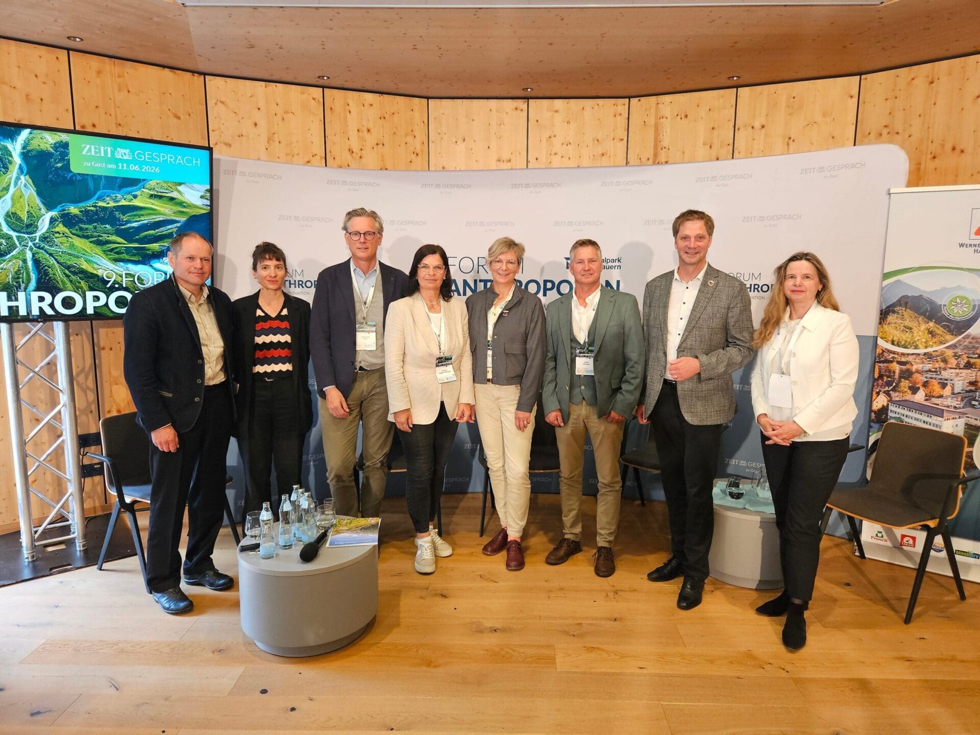 Gruppe von sieben Personen beim Forum Anthropozän vor Holzwand und Bannern