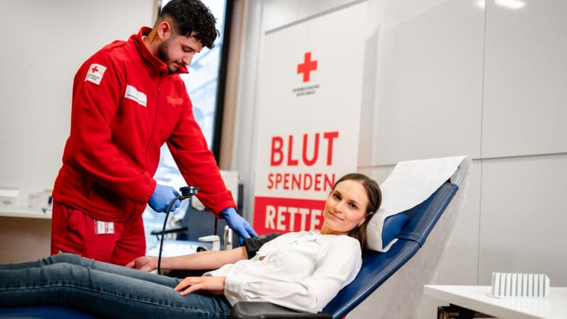 Mitarbeiter des Roten Kreuzes betreut eine Blutspenderin in einem Spendestuhl