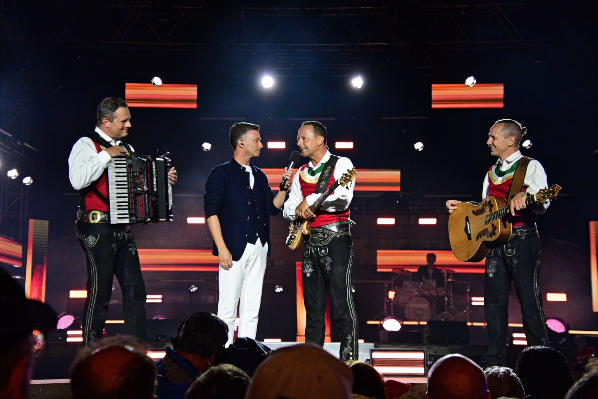 Vier Musiker in Tracht mit Akkordeon Gitarre und Bass auf der Bühne