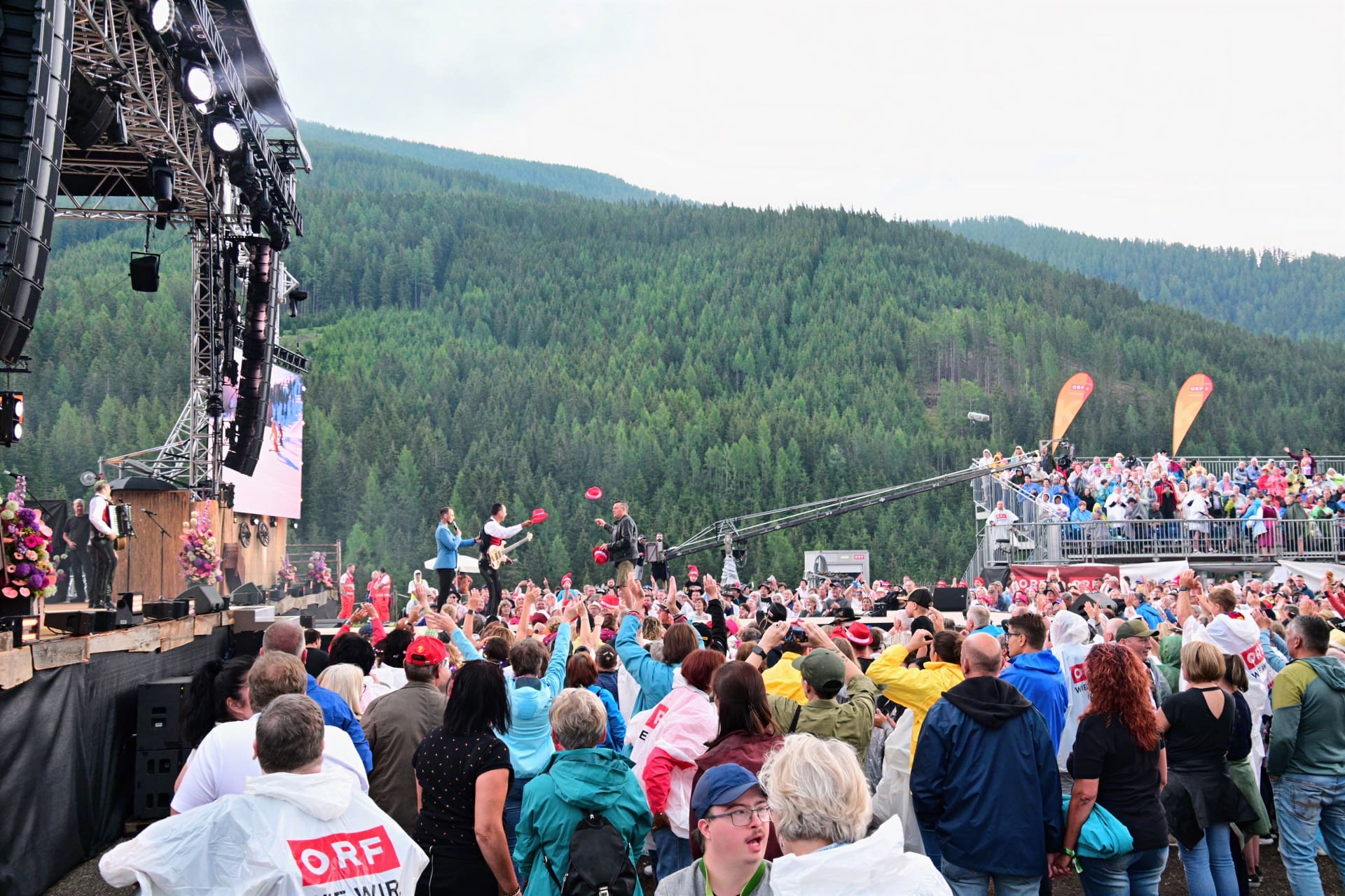 Zahlreiche Zuschauer vor der Bühne beim Sommer Open Air Konzert mit Bergen im Hintergrund