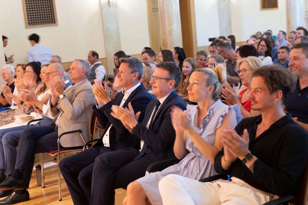 Zuschauer klatschen Beifall in einem festlichen Konzertsaal in Klagenfurt