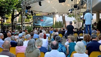 Publikum sitzt auf gelben Stühlen vor einer Bühne bei der Eröffnung der Tage der deutschsprachigen Literatur in Klagenfurt