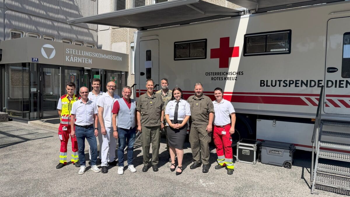 Gruppe von Personen vor einem Blutspendebus des Roten Kreuzes vor der Stellungskommission Kärnten