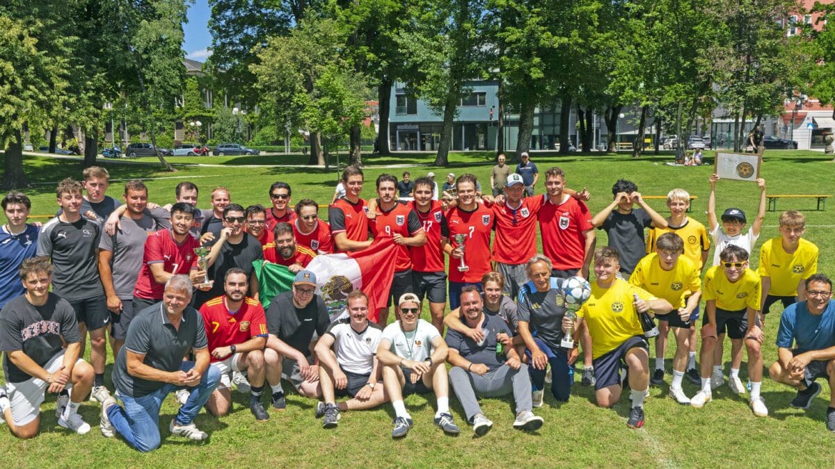 Mannschaften des Kleinfeld-Fußballturniers posieren mit Pokalen auf dem Rasen im Stadtpark