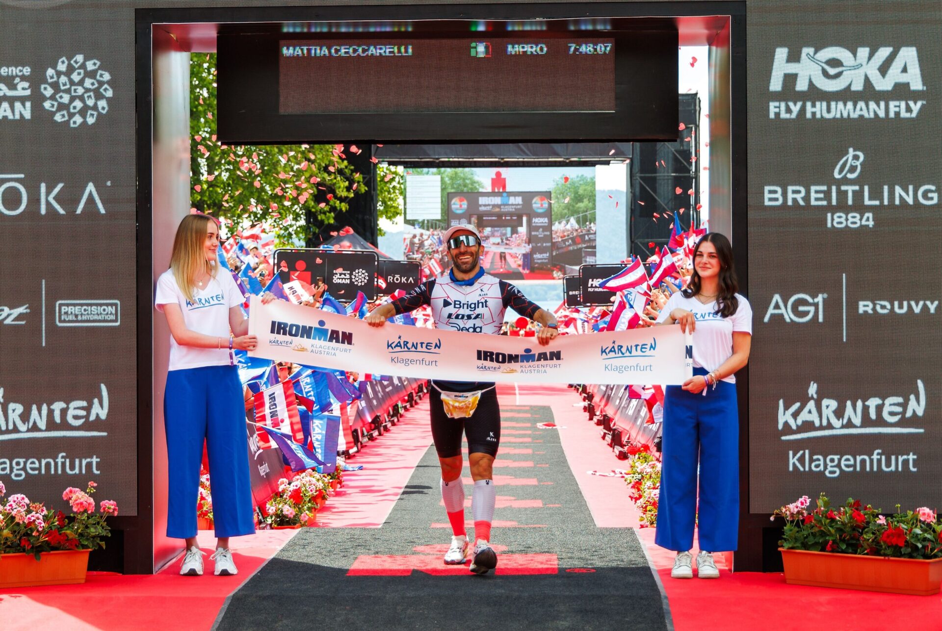 Mattia Ceccarelli läuft durch das Zielband beim Ironman Austria in Klagenfurt