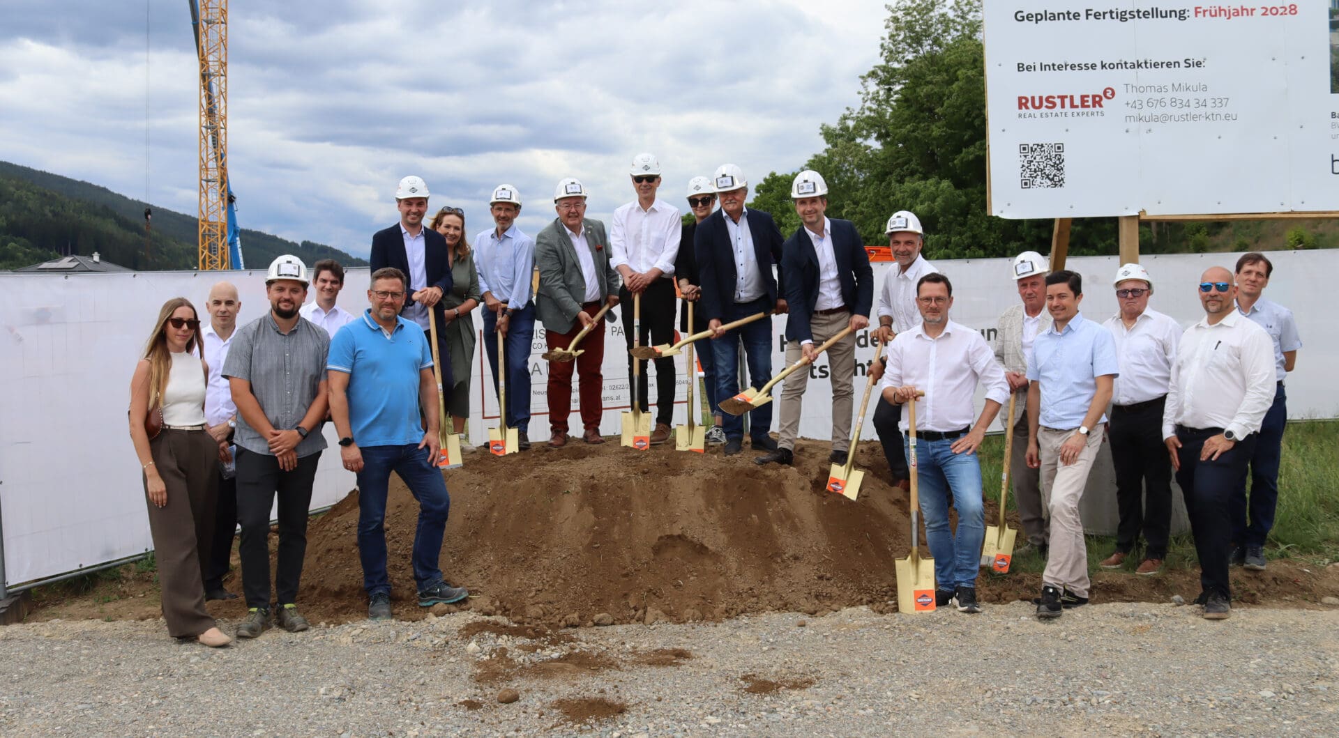 Gruppe von Menschen mit Schaufeln beim Spatenstich auf einer Baustelle in Althofen