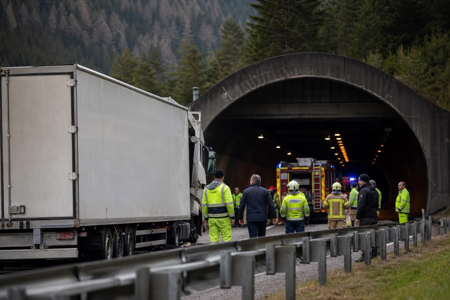 Weißer Lkw steht vor dem Katschbergtunnel mit Einsatzkräften und Feuerwehrfahrzeug