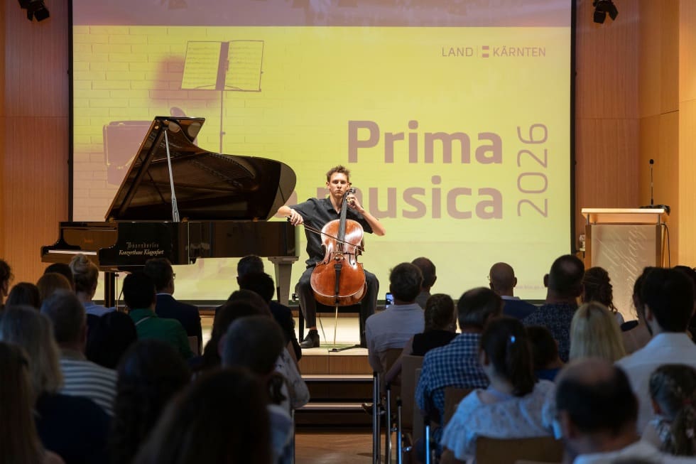Junger Cellist musiziert auf der Bühne vor Publikum und Projektionswand mit Prima musica 2026