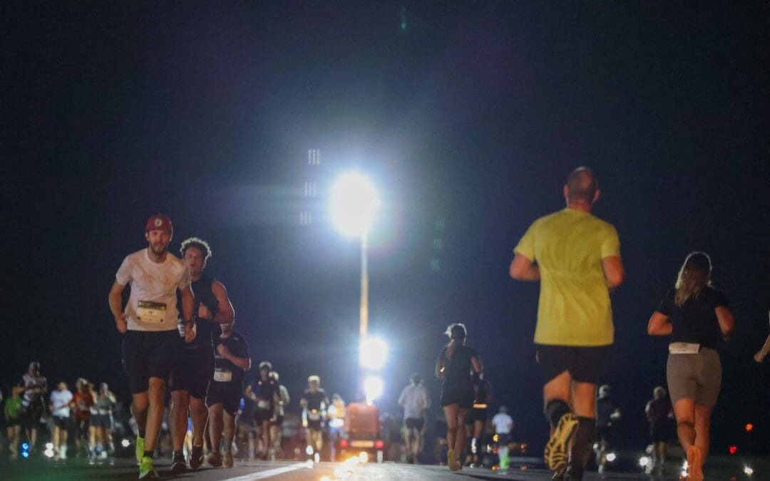 Läufer auf der beleuchteten Startbahn des Flughafens Klagenfurt bei Nacht
