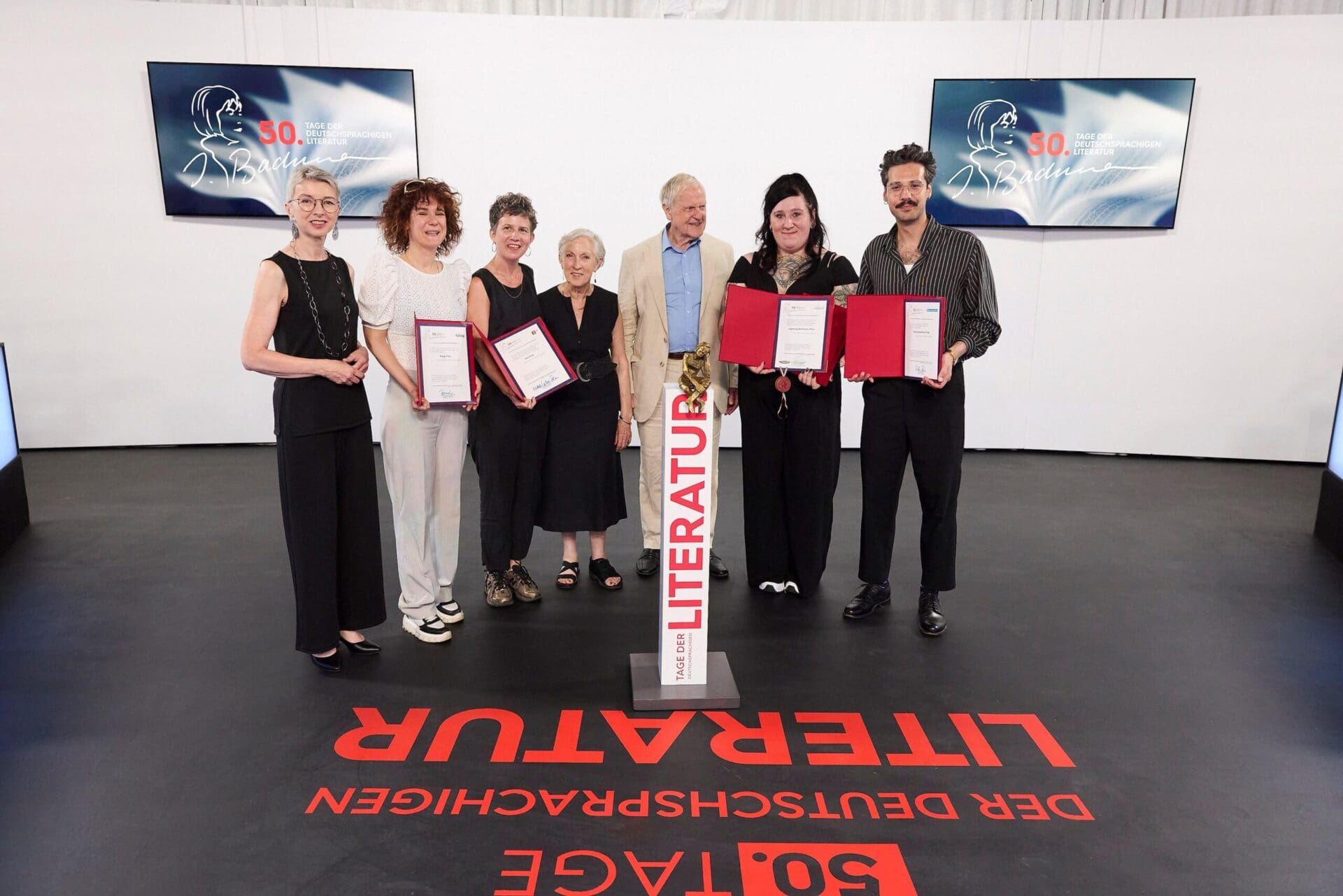 Gruppe von Preisträgern und Jurymitgliedern mit Urkunden bei der Bachmann-Preis-Verleihung