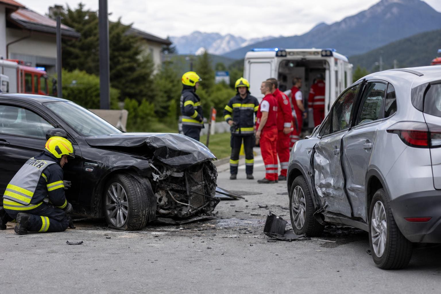Zwei stark beschädigte Autos nach Kreuzungsunfall mit Feuerwehr und Rettungskräften am Ort