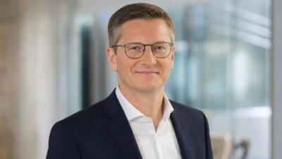 Porträt von Michael Baminger mit Brille im dunklen Anzug und weißem Hemd
