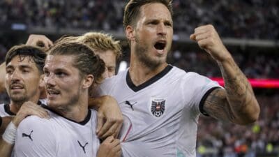 Österreichische Fußballspieler in weißen Trikots feiern jubelnd im Stadion