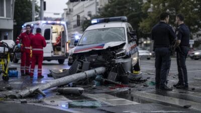 Beschädigtes Polizeiauto nach Kollision mit umgestürzter Ampel auf nasser Straße