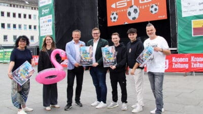Sechs Personen stehen mit Plakaten für City Summer Vibes auf einem Platz.