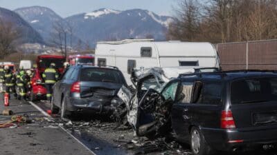 Mehrere stark beschädigte Autos und ein Wohnwagen nach einem Unfall auf der Autobahn