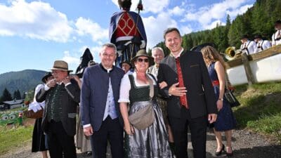 Gruppe von Menschen in Tracht vor einer großen Holzfigur auf der Flattnitz