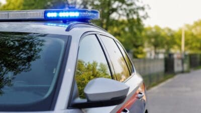 Nahaufnahme eines Polizeifahrzeugs mit eingeschaltetem blauem Blaulicht