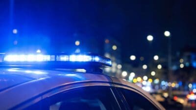 Blaulicht auf dem Dach eines Polizeiwagens bei Nacht in der Stadt