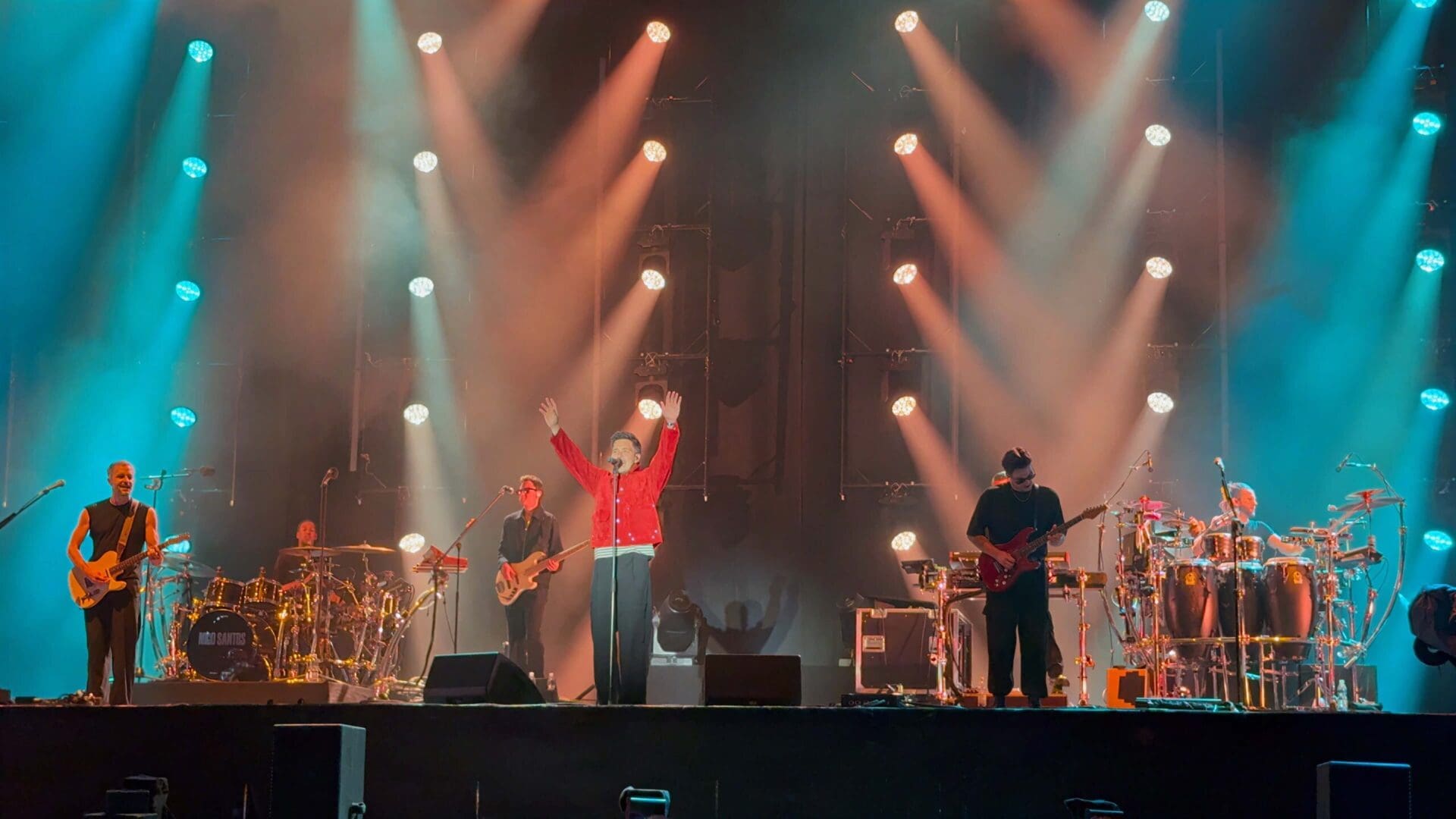 Nico Santos in roter Jacke hebt die Arme auf der Bühne des Donauinselfests