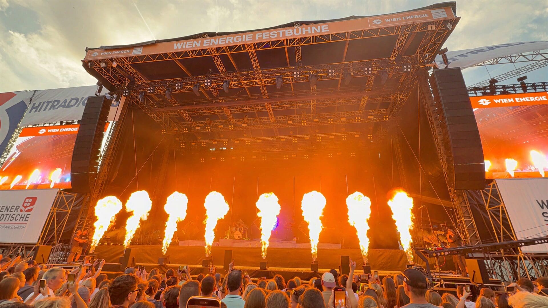 Große Konzertbühne mit oranger Pyrotechnik und jubelndem Publikum beim Donauinselfest in Wien