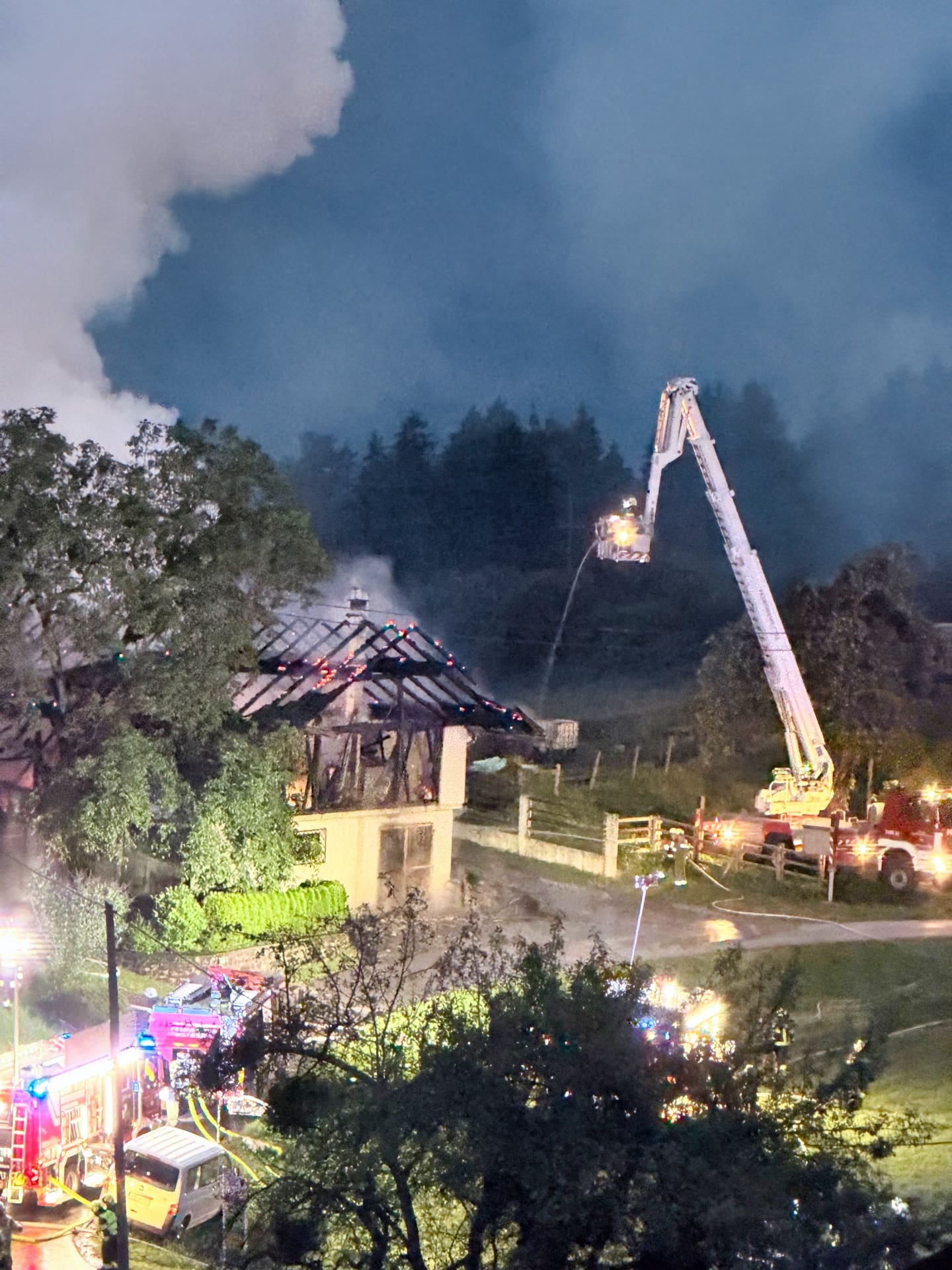 Feuerwehr löscht mit Drehleiter den Brand eines Wirtschaftsgebäudes bei Nacht
