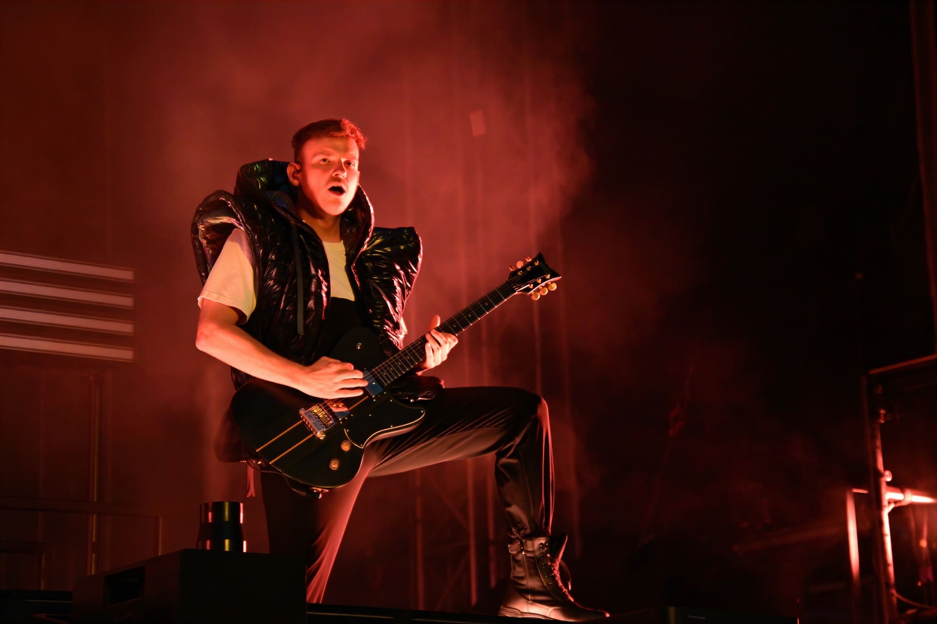 Gitarrist der Band Electric Callboy in Aktion auf der Konzertbühne unter rotem Licht