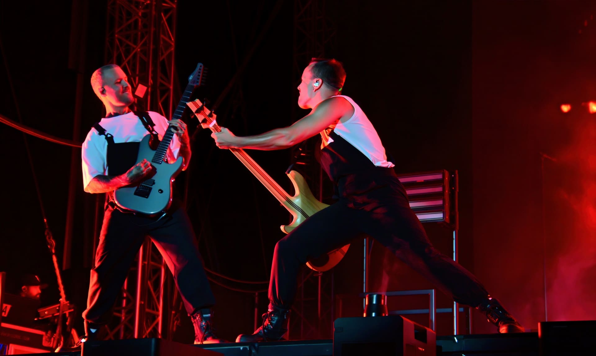 Zwei Musiker von Electric Callboy mit Gitarren auf der Bühne unter rotem Licht in Moosburg