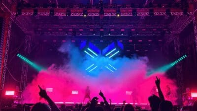Jubelndes Publikum vor pink beleuchteter Bühne mit blauem Logo und Rauch beim Electric Callboy Konzert
