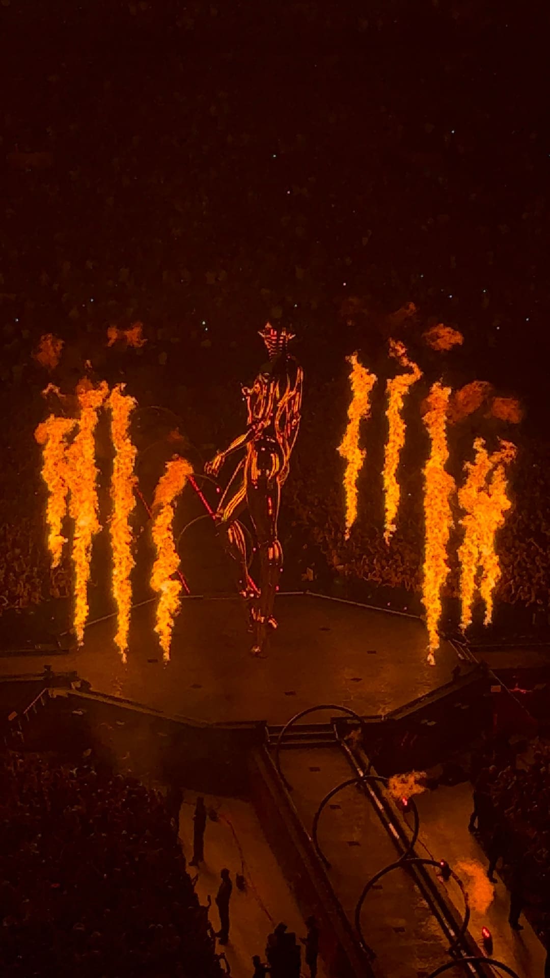 Leuchtende Skelettfigur auf der Bühne umgeben von großen Flammen bei einem Konzert