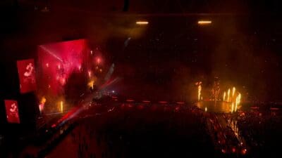 The Weeknd auf einer grossen Bühne mit Pyrotechnik und Flammen in einem vollen Stadion bei Nacht