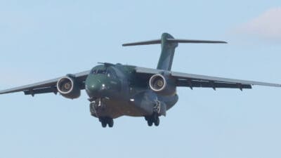 Grünes Militärtransportflugzeug der portugiesischen Luftwaffe im Landeanflug vor blauem Himmel