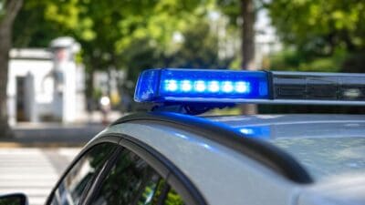 Blaues Blaulicht auf dem Dach eines Polizeifahrzeugs in Nahaufnahme.