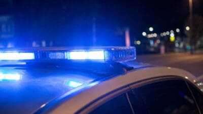 Nahaufnahme eines leuchtenden blauen Blaulichts auf einem Polizeifahrzeug bei Nacht
