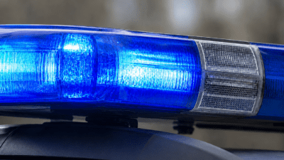 Nahaufnahme einer leuchtenden blauen Einsatzleuchte auf dem Dach eines Polizeifahrzeugs