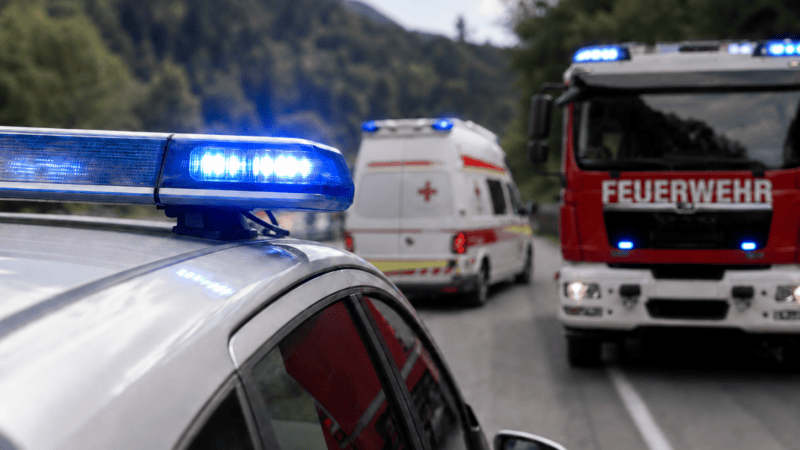 Polizeifahrzeug mit Blaulicht im Vordergrund vor Feuerwehr und Rettungswagen auf Bergstraße