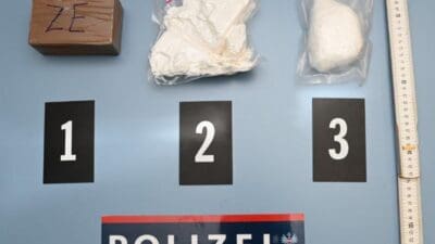 Beweismittel mit Drogenpaketen, nummerierten Karten eins bis drei, Maßstäben und einem Polizeischild der Landespolizeidirektion Kärnten