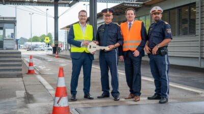 Vier Männer bei der Übergabe eines großen Schlüssels an der Lkw-Kontrollstelle