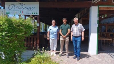 Drei Personen stehen vor dem Eingang der Pizzeria und des Restaurants Primavera am Pressegger See.