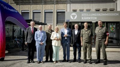 Sieben Personen stehen vor dem Eingang der Stellungskommission Kärnten in Klagenfurt.