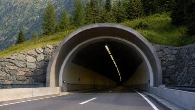 Blick auf die Tunnelöffnung des Katschbergtunnels auf der A10 vor grünen Bergen und Wäldern