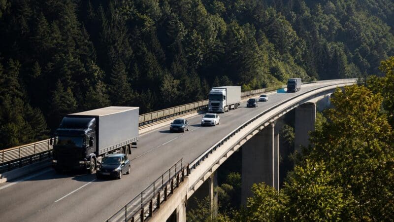 Mehrere Lastwagen und Pkw befahren die zweispurige Luegbrücke am Brenner.